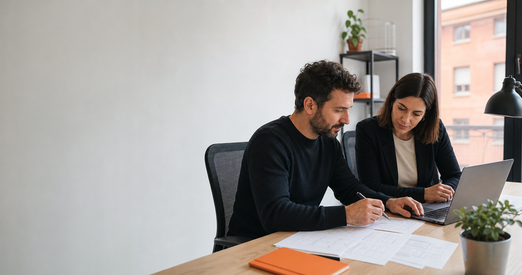 Due professionisti discutono un flusso di software su misura in un ufficio italiano
